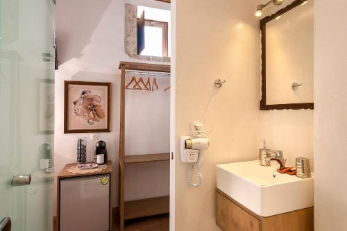 a bathroom with a sink and a mirror at Hamam Suites Sifaka in Chania Town