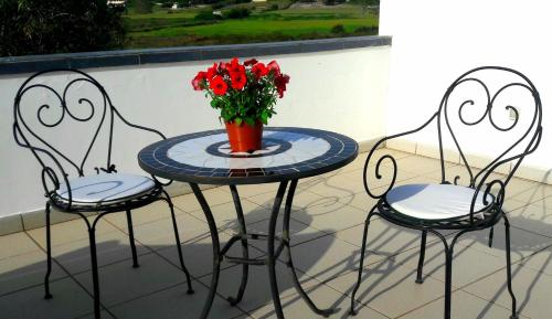 トッレ・デル・オルソにあるVilla Sole e Saleの赤い花瓶の椅子2脚とテーブル