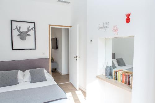 une chambre blanche avec un lit et un miroir dans l'établissement Cannes Le Chabaud, à Cannes