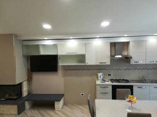 a kitchen with white cabinets and a table with a wine glass at Tramonti di Sole in Tramonti