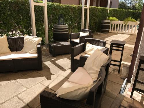 a group of chairs and tables on a patio at Hotel B&B Rispescia Grosseto in Rispescia