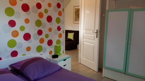 ein Schlafzimmer mit einem Bett und einer Polka-Punkt-Wand in der Unterkunft Appt-Gîte du Relais de Drugy in Saint-Riquier