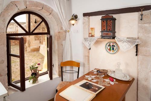 a dining room with a table and a window at Hamam Suites Sifaka in Chania Town