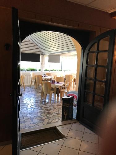 a dining room with tables and chairs and an open door at Hotel B&B Rispescia Grosseto in Rispescia