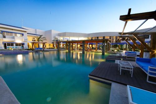 una piscina con sillas azules y un edificio en Hotel Mykonos, en Santiago de Veraguas