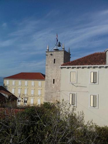 a castle with a flag on top of a building at Apartmani Neva Supetar in Supetar