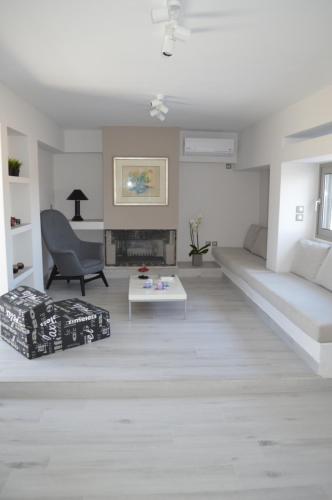 ein weißes Wohnzimmer mit einem Sofa und einem Tisch in der Unterkunft Athens Riviera Loft in Athen