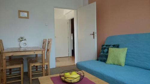 ein Wohnzimmer mit einem blauen Sofa und einem Tisch in der Unterkunft Apartment Provence in Franzensbad