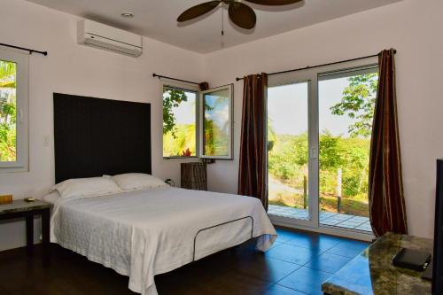 um quarto com uma cama e janelas grandes em Sand Dollar Villa em Boca Chica