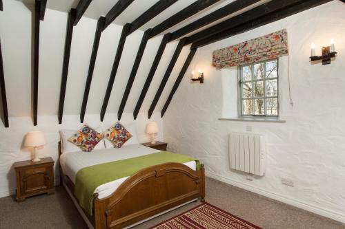 Schlafzimmer mit einem Bett und einem Fenster in der Unterkunft Dunguaire Thatched Cottages in Galway