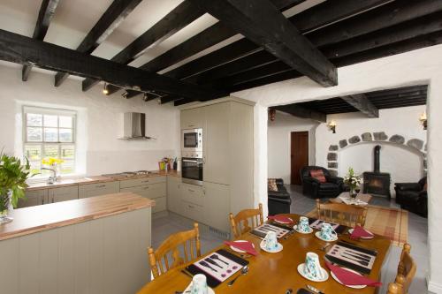 a kitchen and dining room with a table and chairs at Dunguaire Thatched Cottages in Galway