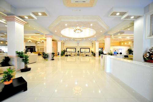 a lobby with a large lobby with white furniture at Gaia Palace in Mastichari