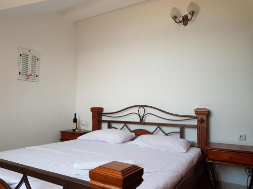 Schlafzimmer mit einem Bett mit einem Kopfteil aus Holz in der Unterkunft Villa Look in Tivat