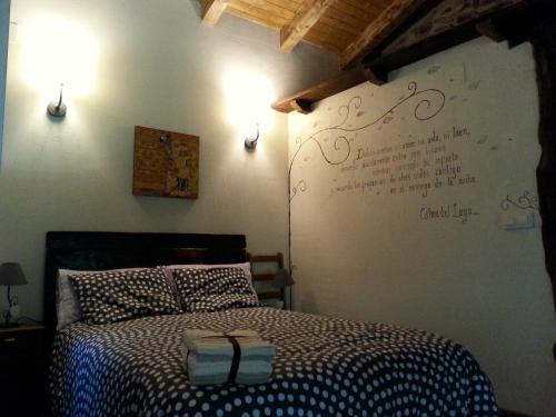um quarto com uma cama com uma escrita na parede em CASA RURAL Calma del Lago em Triufé
