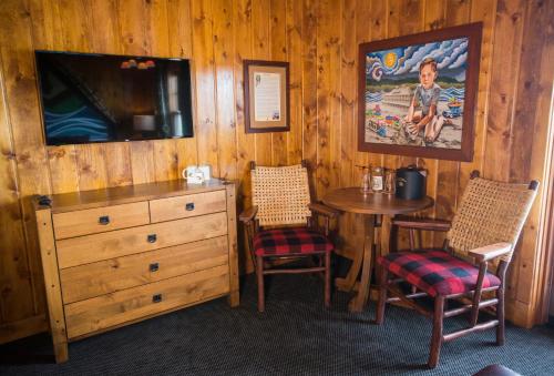 ein Esszimmer mit einem Tisch, 2 Stühlen und einer Kommode in der Unterkunft McMenamins Kalama Harbor Lodge in Kalama