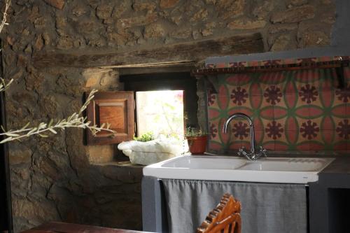 een badkamer met een wastafel in een stenen muur bij La Grulla Gris in Perales del Puerto