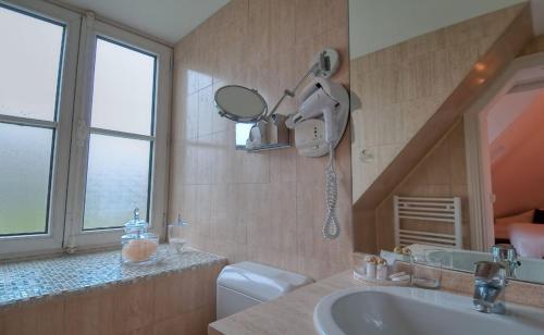 uma casa de banho com um lavatório, um espelho e um WC. em Hotel Cluny Square em Paris