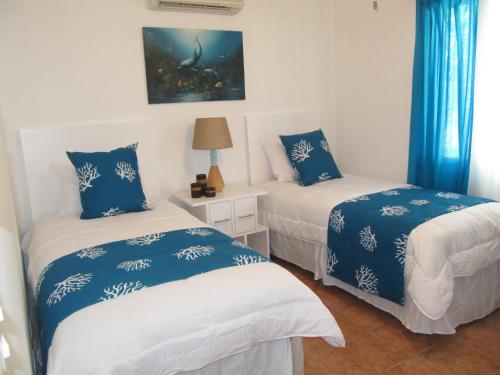 2 camas en una habitación con sábanas azules y blancas en Coco Beach Home, en Coco