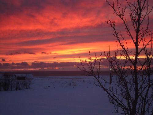 a sunset over a snowy field with a red sky at Hagi 2 Road 62 nr 1 in Hagi