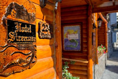 a sign on the side of a wooden building at Hosteria Sirenuse in Mar del Plata