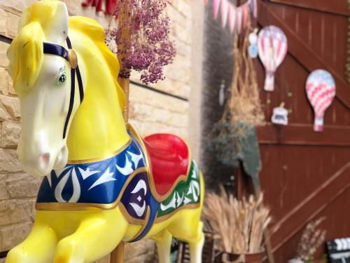 a plastic horse statue sitting next to a building at Yo Muma Homestay in T'ien-wei