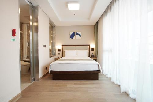 a bedroom with a bed and a large window at Stanford Hotel Busan in Busan