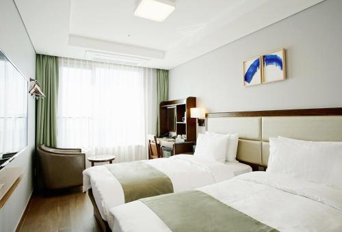 Habitación de hotel con 2 camas y ventana en Stanford Hotel Busan en Busan