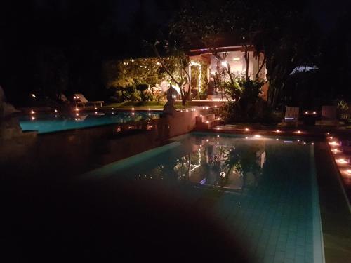 a swimming pool lit up at night with lights at Villa Campi Sorga in Senggigi 