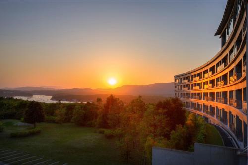 un bâtiment avec un coucher de soleil en arrière-plan dans l'établissement Shima Kanko Hotel The Bay Suites, à Shima