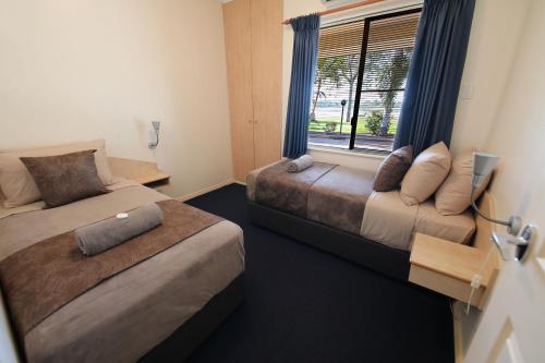 a hotel room with two beds and a window at Lakeview Apartments in Kununurra