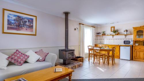 a living room with a couch and a stove at Honeysuckle Cottages in Stanthorpe