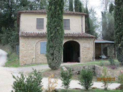 una antigua casa de piedra con un gran árbol en Tenuta Il Tresto, en Poggibonsi