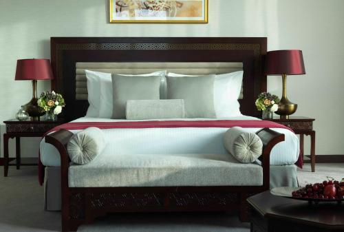 a bedroom with a large white bed with two lamps at Bab Al Qasr Hotel in Abu Dhabi