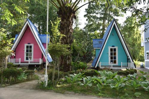 three small houses are sitting next to a tree at ฺBaan Rai Ing Doi in Chaiyaphum