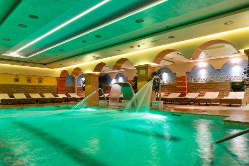 a swimming pool in a hotel with water fountain at Gaia Palace in Mastichari
