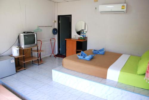 a bedroom with a bed and a television in it at ฺBaan Rai Ing Doi in Chaiyaphum