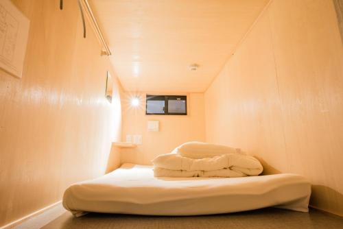 a small room with a bed in a small room at Cafe & Guest House Nagonoya in Nagoya