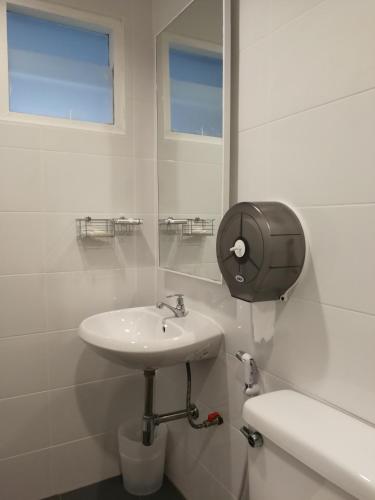 a white bathroom with a sink and a toilet at F Plus F Hostel in Chiang Mai