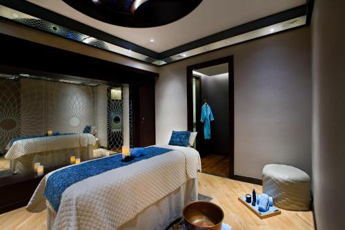 a bedroom with two beds and a mirror at Bab Al Qasr Residence in Abu Dhabi