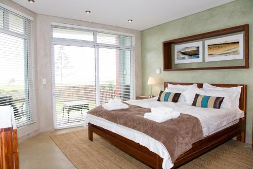 - une chambre avec un grand lit et des serviettes dans l'établissement Atlantik Sicht Apartment, à Swakopmund
