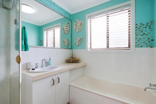 a bathroom with a sink and a mirror at Panoramic Townhouses by Lisa in Merimbula
