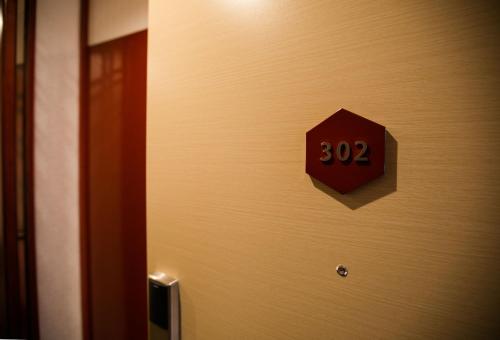 a red sign on a door with the number at Kyoto Kamanza Hotel in Kyoto