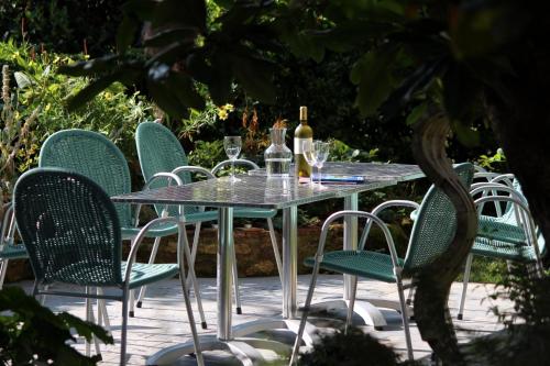 a table and chairs with wine bottles and glasses at Maison Poche in Caupenne-dʼArmagnac