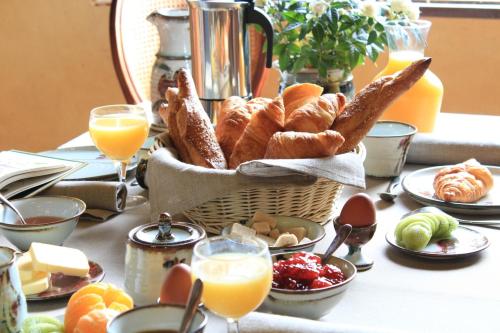 a table topped with a basket of bread and pastries at Maison Poche in Caupenne-dʼArmagnac