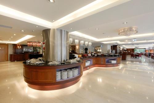 a restaurant with a counter in a large room at Hotel Sunshine in Kaohsiung