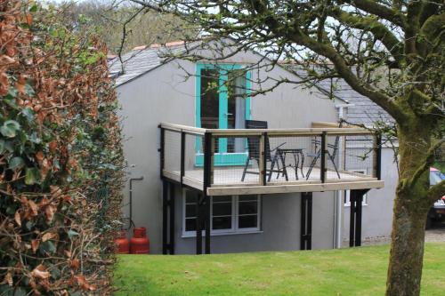 a house with a deck with a table at The Dartmoor Linhay in Yelverton