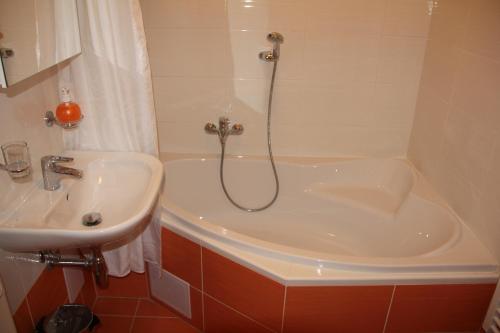 y baño con ducha, lavabo y bañera. en Apartmán City Olomouc, en Olomouc