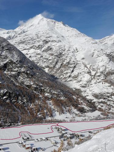 a snow covered mountain with a resort in front of it at Cosy 3.5 pièce à Täsch in Täsch