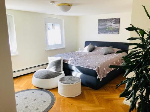 a bedroom with a bed and a chair at Pension Holzgarten in Regensburg