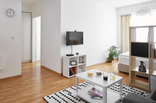 a white living room with a white table and a tv at Moodeight Apartments in Skopje